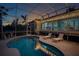 Enclosed pool area with lounge chairs at dusk at 1021 99Th Nw St, Bradenton, FL 34209