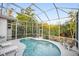 Enclosed kidney shaped pool with lounge chairs at 1021 99Th Nw St, Bradenton, FL 34209