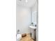 Modern powder room with pedestal sink, toilet, and LED mirror at 111 S Pineapple Ave # 607, Sarasota, FL 34236