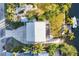 Aerial view of property with a lush yard, private dock, boat and ample parking, set amidst tropical surroundings at 115 Burns Rd, Terra Ceia, FL 34250