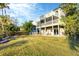 Spacious backyard featuring a well-maintained lawn and a charming two-story home with balconies at 115 Burns Rd, Terra Ceia, FL 34250