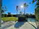 Backyard featuring a grassy lawn, waterfront access, boat ramp, mature trees and palms on a sunny day at 115 Burns Rd, Terra Ceia, FL 34250