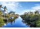 Scenic canal-front property with boats docked, lush foliage, and charming homes at 115 Burns Rd, Terra Ceia, FL 34250