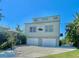 Exterior of a modern two-story home with a two-car garage, spacious driveway, and well-maintained landscaping at 115 Burns Rd, Terra Ceia, FL 34250