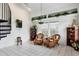 Bright living room featuring tile floors, a spiral staircase, and decorative shelving with plants and coastal decor at 115 Burns Rd, Terra Ceia, FL 34250