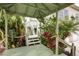 Charming walkway framed by tropical plants and a cozy gazebo leading to the main house at 115 Burns Rd, Terra Ceia, FL 34250