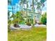 Landscaped yard with tropical plants and a two-story house in the background at 115 Burns Rd, Terra Ceia, FL 34250