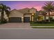 Luxury two-story house with three-car garage and mature landscaping at sunset at 13013 Ramblewood Trl, Bradenton, FL 34211