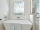 Spa-like bathroom showcasing a freestanding tub and textured tile, illuminated by natural light at 1519 Harbor Dr, Sarasota, FL 34239