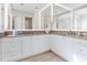 Bright bathroom with double vanity featuring elegant cabinetry, stone countertops and backlit mirrors at 1519 Harbor Dr, Sarasota, FL 34239