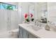 Bright bathroom featuring a glass shower, a gray vanity, and a framed mirror over the sink at 1519 Harbor Dr, Sarasota, FL 34239