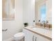 Elegant half bathroom with a beige countertop sink, decorative art, and crisp white walls at 1519 Harbor Dr, Sarasota, FL 34239