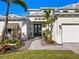 Charming home entrance with lush landscaping, brick walkway, and a modern glass front door at 1519 Harbor Dr, Sarasota, FL 34239