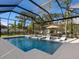 Relaxing screened pool area featuring a pool, spa, lounge chairs, and lush tropical landscaping at 1519 Harbor Dr, Sarasota, FL 34239