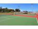 Well-maintained tennis court featuring green and red surfaces, surrounded by fencing and greenery at 1519 Harbor Dr, Sarasota, FL 34239