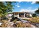 Back exterior of the home with a desert landscape, a small pond, and a wooden bridge at 1716 Forest Rd, Venice, FL 34293