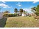 Backyard featuring a shed, palm trees, hedges, and a green lawn at 1716 Forest Rd, Venice, FL 34293