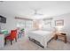 Bright bedroom featuring a ceiling fan, plush rugs, and a dedicated desk area with a red chair at 1716 Forest Rd, Venice, FL 34293