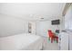 Bright bedroom featuring white closet, modern ceiling fan and a dedicated desk area with a red chair at 1716 Forest Rd, Venice, FL 34293