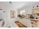 Bright kitchen with white appliances, under cabinet shelving, and patterned backsplash at 1716 Forest Rd, Venice, FL 34293