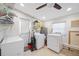 Spacious laundry room featuring white appliances, shelving, and ample storage space for household needs at 1716 Forest Rd, Venice, FL 34293