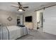 Bedroom with barn door to en-suite bath, ceiling fan, and carpeted floors at 1925 146Th E Ter, Parrish, FL 34219