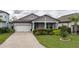 Two-story home with gray siding, white garage door, and landscaping at 1925 146Th E Ter, Parrish, FL 34219