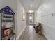 Long hallway with white wainscoting, wood-look tile floors, and bench at 1925 146Th E Ter, Parrish, FL 34219