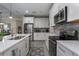 Modern kitchen with white cabinets, stainless steel appliances, and quartz countertops at 1925 146Th E Ter, Parrish, FL 34219