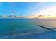 Tranquil beach scene at sunset, featuring calm ocean and pier at 2295 Gulf Of Mexico Dr # 115S, Longboat Key, FL 34228