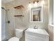 Clean bathroom with white vanity, tiled shower, and floating shelves at 2503 Bispham Rd, Sarasota, FL 34231