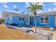 Light blue house with palm trees and a landscaped yard at 2762 W Vina Del Mar Blvd, St Pete Beach, FL 33706