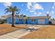 Light blue house with palm trees and a spacious yard at 2762 W Vina Del Mar Blvd, St Pete Beach, FL 33706