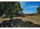 Backyard view, showcasing a screened patio and large tree at 3055 Holiday Lake Dr, Holiday, FL 34691