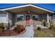 Inviting front entrance with red door and landscaping at 3055 Holiday Lake Dr, Holiday, FL 34691