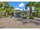 Tropical landscaping surrounds a carport and spacious gravel driveway at 325 Casey Key Rd, Nokomis, FL 34275