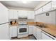 Galley kitchen with white cabinets and wood countertops at 3275 Beneva Rd # 104, Sarasota, FL 34232