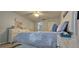 Comfortable bedroom with a patterned comforter, side tables, ceiling fan and ensuite bath at 3401 Rochelle Ct # 131, Clearwater, FL 33761