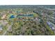 An aerial view of a tree-filled lot with possible building options near a golf course and ponds at 3864 Gocio Rd, Sarasota, FL 34235