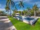 Stunning L'Ambiance entrance with a decorative water feature, palm trees, and manicured lawn at 415 L Ambiance Dr # C404, Longboat Key, FL 34228