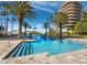 Inviting community pool and spa featuring palm trees and luxury high-rise buildings in the background at 415 L Ambiance Dr # C404, Longboat Key, FL 34228