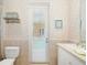 Bathroom with a toilet, sink, and access to the pool at 45 Grand Palms Blvd, Englewood, FL 34223