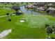 Green golf course with sand trap and palm trees at 45 Grand Palms Blvd, Englewood, FL 34223