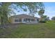 House backyard view, featuring a patio and lush landscaping at 4728 Sand Trap Street E Cir, Bradenton, FL 34203