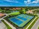 Overhead view showcasing immaculate tennis courts and beautifully landscaped community with pond at 4728 Sand Trap Street E Cir, Bradenton, FL 34203