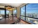 Dining area with dark wood table, modern chandelier, and expansive windows with city and water views at 50 Central Ave # 17Phc, Sarasota, FL 34236