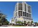 Upscale high-rise condominium building with balconies and street-level commercial spaces, set against a clear blue sky at 50 Central Ave # 17Phc, Sarasota, FL 34236