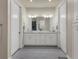 Double vanity bathroom with white cabinets, gray tile flooring, and a large mirror at 5099 Flag St, Sarasota, FL 34232