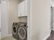 Laundry room with side-by-side washer and dryer and overhead cabinets at 5099 Flag St, Sarasota, FL 34232