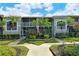 Another view of condo building, showcasing landscaping and walkway at 5211 Mahogany Run Ave # 124, Sarasota, FL 34241